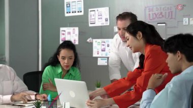 Profesyonel başarılı iş ekibi dizüstü bilgisayar kullanarak birlikte çalışıyor. Bir grup iş adamı projeyi tartışırken Asyalı genç iş kadını dizüstü bilgisayar getiriyor. Yönlendirici.