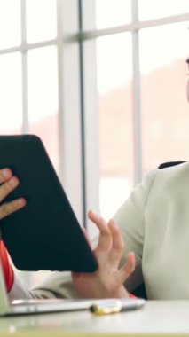Modern ofis odasındaki masada çalışan iş adamları mali veri raporlarını incelerken .