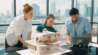 Akıllı mimar takımı ev tasarımı hakkında tartışırken yakışıklı erkek işçi dizüstü bilgisayar kullanarak fikir sunuyor. Profesyonel mühendis paylaşımı, beyin fırtınası tasarımı. İş tasarımı. İzleme