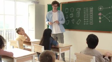 Öğrenciye bakarken, sınıfta matematik teorisi hakkında konuşan ve açıklayan beyaz bir öğretmen. Tahtanın önünde durup tahtaya işaret eden yetenekli bir eğitmen. Pedagoji.