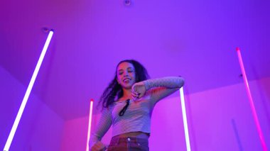 Latin dansçıların kameraya bakıp şehrin pop müziğiyle dans ettiği düşük açılı kamera. Profesyonel çekici hipster, mor veya neon ışıklı hip hop şarkısına geçiyor. Şık bir kumaş. Mutluluk.