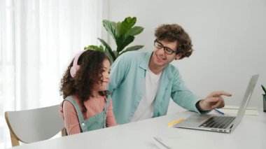 Amerikalı kız, kod yazmayı ve mühendislik yazmayı öğrenirken olumlu baba da birlikte çalışıyor ve programlama kodunu veya sistemini özenle göstermek için dizüstü bilgisayarına işaret ediyor. Pedagoji.