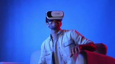 VR gözlük takan zeki bir adam ve metaevrene girmek için heyecanlı. Çekici oyuncu sanal gerçeklik dünyasını bağlarken ve hareket ederken veya etrafa bakarken fantezi oyunu oynuyor. Eğlence için. Aygıt.