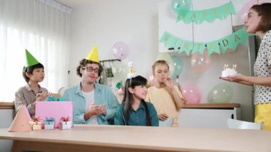 Mutlu kız doğum gününü kutlarken beyaz anne doğum günü pastasını tutarken güzel bir aileyle şarkı söylüyor. Çekici anne pasta getiriyor ve parti şapkası takıp odaya giriyor. Pedagoji.