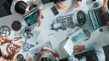 Akıllı mühendis ekibinin günlük giysiler içinde metal teçhizatlı, hesap makineli, yapışkan notlu türbin motor yapısından bahsetmesi zaman kaybı. Bir grup teknisyen toplantıda not alıyor. Hizalama.