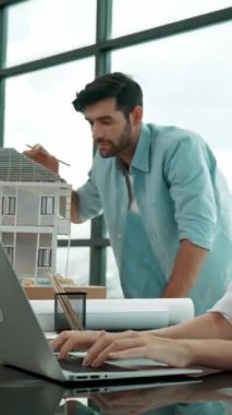 Meslektaşına ev tasarımından bahsederken profesyonel mühendis ölçüm modeli. Laptop analiz verilerini kullanan zeki genç bir mimar. İç işleri ekibi gökdelen ile birlikte çalışıyor. İzleme