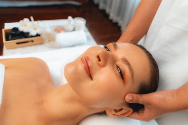 Kafkasyalı kadın stres önleyici kafa masajından ve lüks tatil beldesi ya da otel spa salonundaki modern ışık ortamında yüz güzelliği eğlencelerini şımartmaktan hoşlanıyor. Sessiz.