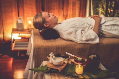 Aromaterapi masajı ambiyansı ya da spa salonu kompozisyon düzeneği bulanık kadınlara odaklı dekor mumları ve spa aksesuarları ile tatil köyü veya otel arka planında keyifli aroma spa masajı yapan. Sessiz.