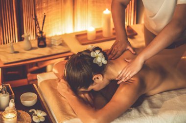 Beyaz kadın müşteri stres önleyici spa masajının keyfini çıkarıyor ve lüks otel ya da otelde sıcak mum ışığında güzellik teniyle eğleniyor. Sessiz.