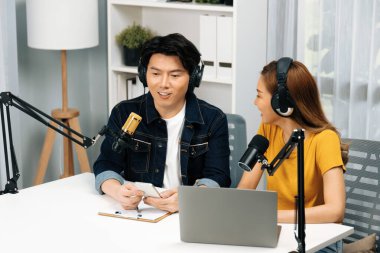 Gülümseyen radyo etkili sunucular, kulaklık takıp sosyal medyayı canlı yayında dinleyicilere telefon ve dizüstü bilgisayarla canlı yayınlıyorlar. İnfobahn.