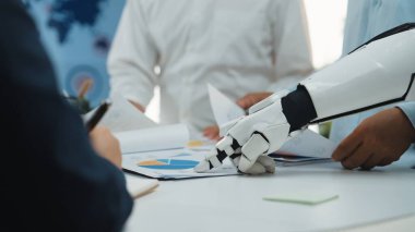 Bir insan ve bir robot, teknoloji alanındaki büyüme ve yenilik stratejilerini araştırmak için bir iş toplantısında birlikte çalışırlar. Noogenesis