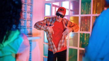 Kafkas dansçısı dans ederken çeşitli arkadaşları gece kulübünde neon ışıkta ayak seslerine bakıyor. Çoklu etnik kökenli hipsterin serbest stil müziğe geçişi ve mutlu bir adamın kameraya bakışıyla. Mutluluk.