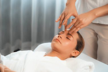 Kafkasyalı kadın stres önleyici kafa masajından ve lüks tatil beldesi ya da otel spa salonundaki modern ışık ortamında yüz güzelliği eğlencelerini şımartmaktan hoşlanıyor. Sessiz.