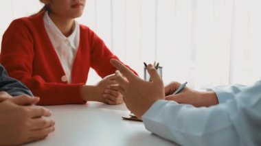 Çift, kısmen hamilelik planlaması için hastanede jinekologla doğum danışmanlığına gidiyor. Karı ve koca doktor randevusu boyunca dikkatle dinlerler. Ağır çekim. Katı.