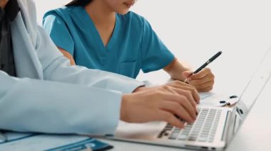 Hastane masasında birlikte çalışan ve tıbbi tedavi planlayan çeşitli profesyonel sağlık görevlileri. Takım çalışması başarılı hastalıklara ve hastalıklara yol açar. Ağır çekim. Katı.