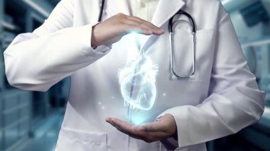 Hastanede kalp anatomisi hologramını tutan profesyonel doktorlara yakın çekim. Teknoloji yeniliklerini kullanarak kalp ameliyatına hazırlanan zeki bir tıp çalışanı. Kardiyoloji. İyileştirici.