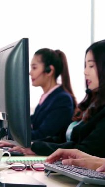 Ofiste çalışan kulaklık takan işadamları uzak müşteri ya da meslektaşlarını desteklemek için çalışıyorlar. Arama merkezi, tele pazarlama, müşteri destek acentesi telefon görüşmesinde hizmet sunar.