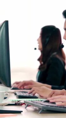 Ofiste çalışan kulaklık takan işadamları uzak müşteri ya da meslektaşlarını desteklemek için çalışıyorlar. Arama merkezi, tele pazarlama, müşteri destek acentesi telefon görüşmesinde hizmet sunar.