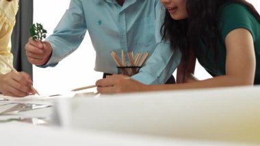 Mimar ve güvenlik mühendisi, ağaç kullanım planının konumu, mimari belge, ölçüm aracı ve ahşap bloğun modern ofiste etrafa saçılması gibi konuları tartışıyor. Tanımlama.