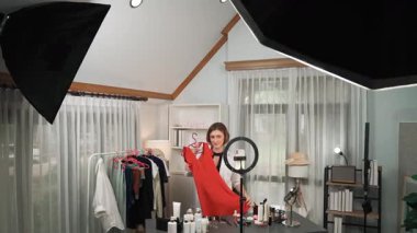 Kadın nüfuzlu kişi video görüntülerini canlı yayınlıyor. Kıyafetler sosyal medyada ya da blogda yer alıyor. Stüdyo ışıklandırmalı mutlu genç kız çevrimiçi pazarlama oturumu yayını için..