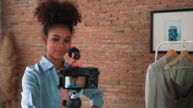 Kadın nüfuzlu kişi canlı yayında video görüntülerini çekiyor. Kıyafetler sosyal medya ya da blog için çok önemli. Stüdyo ışıklandırmalı mutlu genç kız çevrimiçi pazarlama oturumu yayını için..