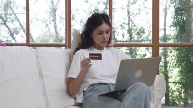 Kadın alışverişi ya da internet pazarında online ödeme modern yaşam tarzı için satılık eşyalar arıyor ve canlı siber güvenlik yazılımı tarafından korunan cüzdandan çevrimiçi ödeme için kredi kartı kullanıyor