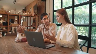 Baharda Cafe Garden 'da dizüstü bilgisayarda çalışan genç bir çift kahve dükkanındaki dinginlik ortamının tadını çıkarıyor. Uzaktan çalışan ya da blog yazan dijital göçebe ya da üniversite öğrencisi. Yararlı