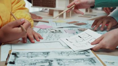 Çocukların aktif bir şekilde mimari modeller ve zemin planları üzerinde işbirliği yaptığı, etkileşimli faaliyetler yoluyla yaratıcılığı ve takım çalışmasını teşvik ettiği canlı bir sınıf sahnesi. SACTR