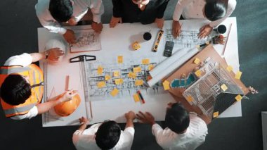 Yetenekli mühendis takımının ev modelini ölçerken konuştuğu tepeden tırnağa görüntü. Birlikte çalışan ve mühendislik inşaatı için plan yapan bir grup akıllı iç mimar. Hizalama.