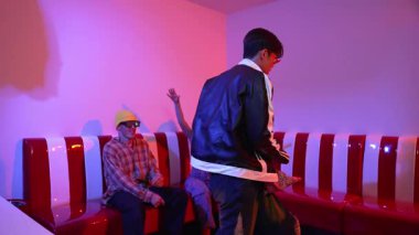 Asyalı bir adam pop müzikle dans ederken, çok kültürlü bir arkadaş evde ışık altında oturuyor. Çekici bir sokak dansçısı kameraya bakarken hip hop müzik dinliyor. Mutluluk.