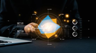 Renkli geometrik grafikler ve analitik öngörülerle dolu bir dizüstü bilgisayarın yanında cep telefonunu tutan bir elin olduğu fütüristik bir veri analiz sahnesi. Dörtgen