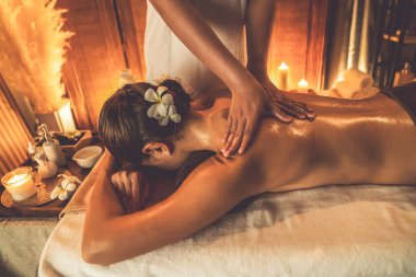 Beyaz kadın müşteri stres önleyici spa masajının keyfini çıkarıyor ve lüks otel ya da otelde sıcak mum ışığında güzellik teniyle eğleniyor. Sessiz.