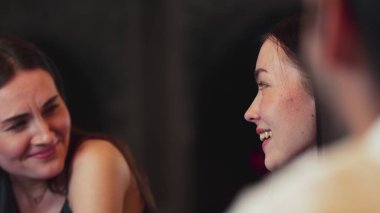 Lüks bir kokteyl barında grup arkadaşıyla gülümseyen güzel bir kadının portresi. Gece kulübünde sosyetik etkileşim için doğal yüz güzelliğini kostüm içinde yakalamak. Vinosity.