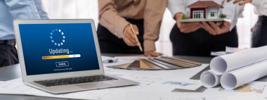 İç mimar tasarımcı grubu, daha kesin tasarım için planlar ve dizüstü bilgisayar ekran mimari yazılımı üzerinde birlikte tartışıyorlar. Modern ev tasarımı ve yenileme. İçgörü