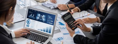 İş zekası ve veri analizi kavramı. Analizci ekibi laptop ekranında finansal veri analizi üzerinde çalışıyor. Etkili iş stratejik planlama için pazarlama göstergesi olarak. İçgörü