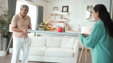 Yaşlı bir adam evde partneriyle top yuvarlama oyunu oynuyor, zihinsel ve fiziksel sağIık için el-göz koordinasyonu, odaklanma ve motor becerileri pratiği yapıyor. Sağlık hizmetleri konseptini engelliyor. Myrmidon.