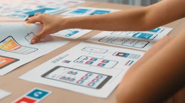 Mobil uygulama için kullanıcı arayüzü prototipi ya da masadaki program modeliyle birlikte web sitesi planlaması yapan bir şirket çalışanı. UX UI tasarımcısı kullanıcı dostu arayüz planını dikkate alır. Sinerjik