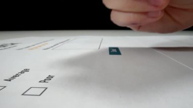 Yakın çekim makro çekim hareketi el geri besleme anket formunu müşteri memnuniyeti için kalemle dolduruyor. Anket formu pazarlama ve kalite değerlendirme kavramı olarak mükemmel derecelendirme geribildirimi alır.