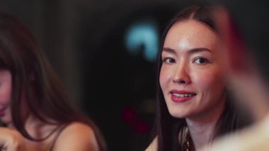 Lüks bir kokteyl barında grup arkadaşıyla gülümseyen güzel bir kadının portresi. Gece kulübünde sosyetik etkileşim için doğal yüz güzelliğini kostüm içinde yakalamak. Vinosity.