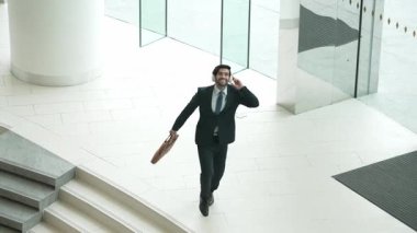 İş adamı kapıda dans ederken kulaklıkla şarkı dinler. Yöneticinin başarılı bir projeyi kutlamak için müziğe yönelmesi ya da terfi alma ve satışları artırma konusunda iyi haberler. Sevinçli..