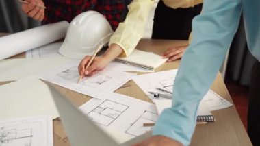 Mimarlık ve güvenlik mühendisi, modern ofiste dizüstü bilgisayarda mimari belge ve ahşap blokla sergilenen planlar hakkında tartıştı. - Yakın çekim. Tanımlama.