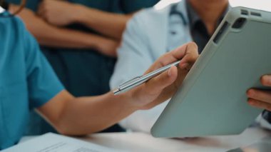 Hasta için hastane masasında çalışan ve tıbbi tedavi planlayanlardan oluşan profesyonel bir ekip. Takım çalışması başarılı hastalıklara ve hastalıklara yol açar. Ağır çekim. Katı.