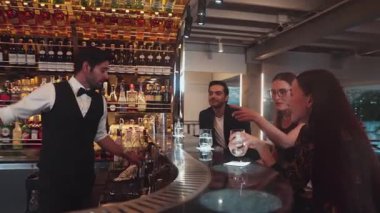 Gece kulübündeki lüks gece kulübünde, içki tezgahında çalışan akıllı barmen servisinde çift ya da arkadaş grubuyla gülen VIP müşterilere özel cin kokteyli servisi. Vinosity.