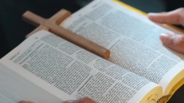 İncil 'in çapraz sayfası, kitabı dua kucağına yerleştirirken. Aşkı, barışı, özgürlüğü temsil ediyordu. Çeşitli kızlar kitap okurken ve kucak açarken el ele tutuşuyorlar. Sempozyum.