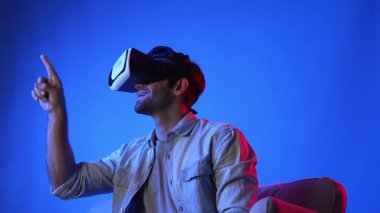 VR gözlük takan zeki bir adam ve metaevrene girmek için heyecanlı. Çekici oyuncu sanal gerçeklik dünyasını bağlarken ve hareket ederken veya etrafa bakarken fantezi oyunu oynuyor. Eğlence için. Aygıt.