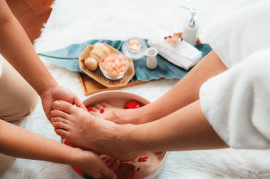 Adam lüks kaplıcalarda mutlu ayak masajına devam ederken, masör de hafif gün ışığı atmosferinde refleksoloji terapisi ya da otel ayak spa 'sında. Sessiz.