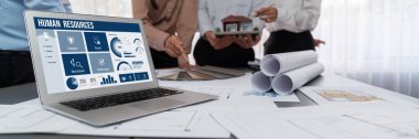 İnsan kaynakları yönetim yazılımı bilgisayar ekranında insan kaynakları çalışanlarının işe alım, maaş bordrosu, personel araması ve KPI değerlendirme çalışmalarını yönetmesine yardımcı oluyor