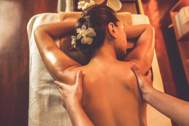 Beyaz kadın müşteri stres önleyici spa masajının keyfini çıkarıyor ve lüks otel ya da otelde sıcak mum ışığında güzellik teniyle eğleniyor. Sessiz.