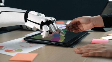 Robotik bir el ve bir insan eli modern ofis ortamında dokunmatik bir tablet üzerinde dijital sanat yaratıcılığı ile ilgilenir. Yaratıcılık ve yenilik sergiler.