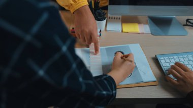 Modern bir çalışma alanında işbirliği yapan iki birey, tasarım sürecine bağlanıyor ve proje geliştirmek için teknoloji ve yaratıcı araçlarla çevrili renkleri seçiyor. SACTR